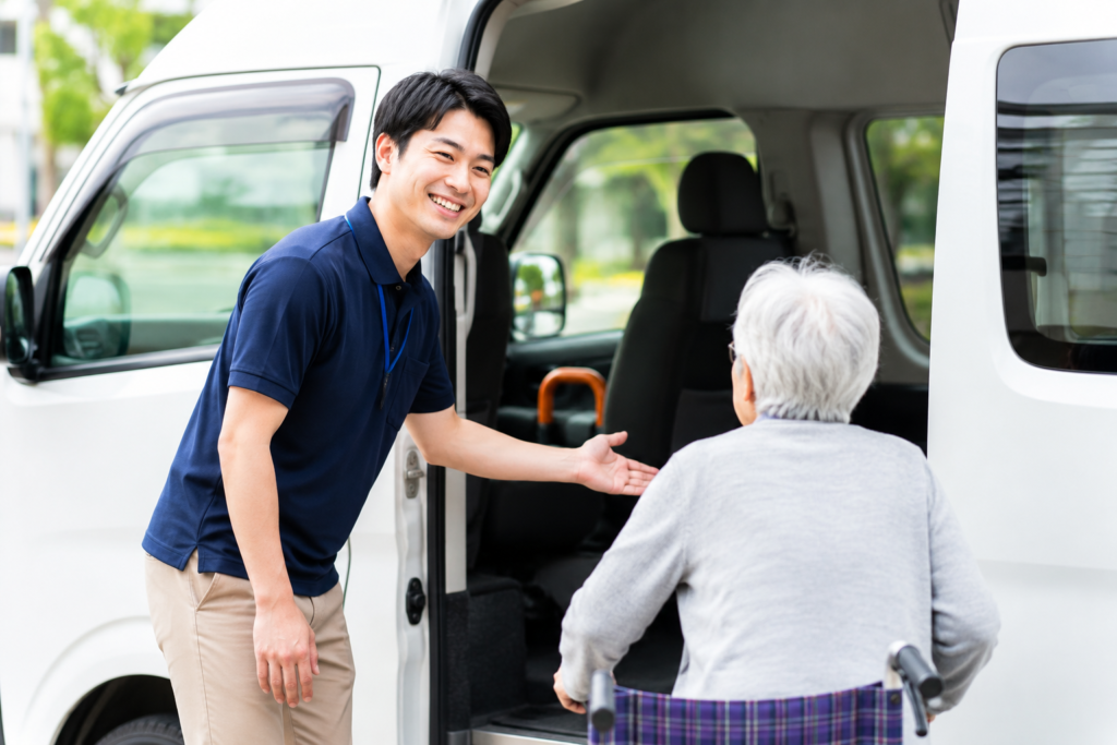 福祉送迎ドライバーがお客様の乗車をサポートしている様子。普通免許から始められる地域密着の送迎サービス